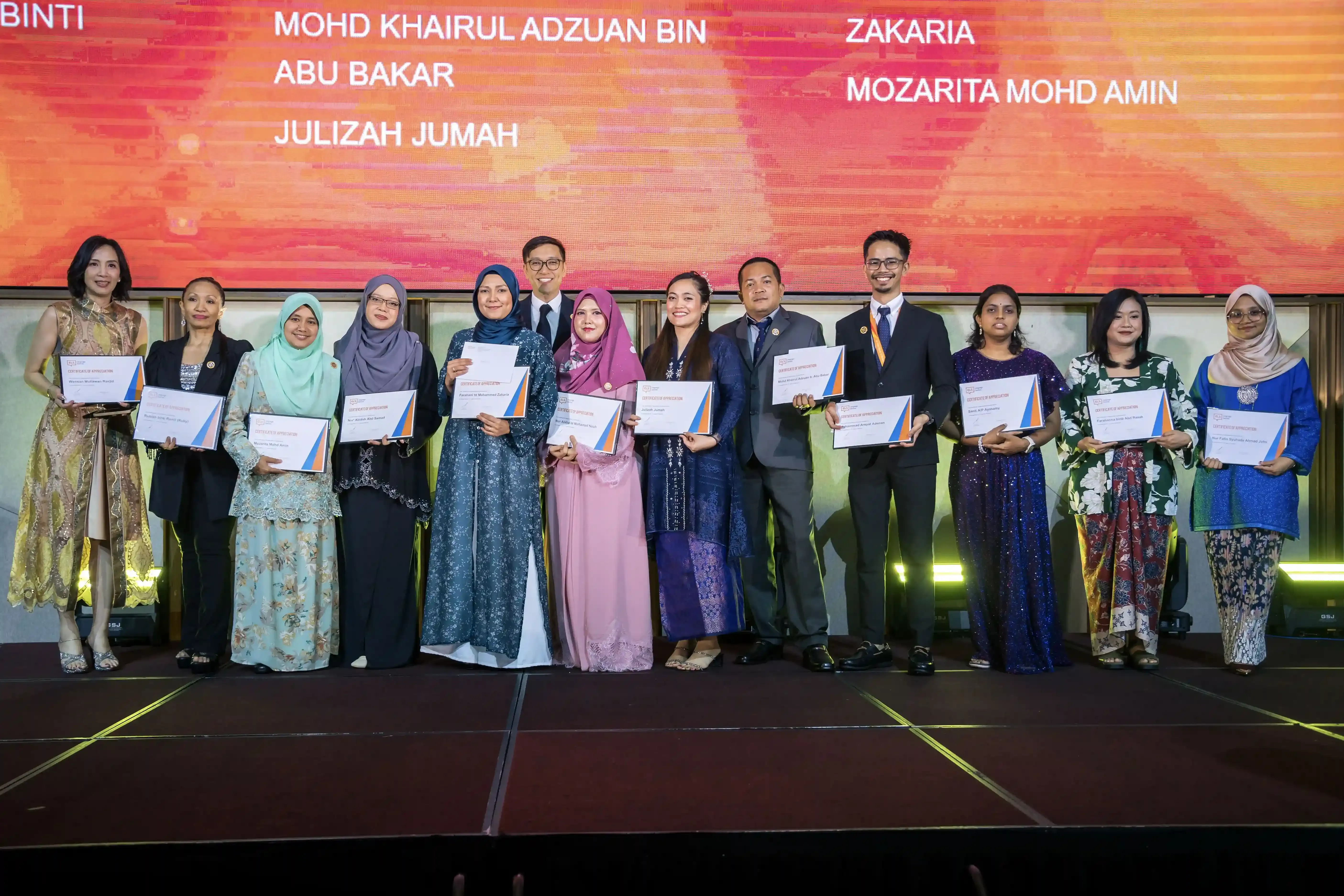 A group of ELS staff onstage after receiving their long service awards